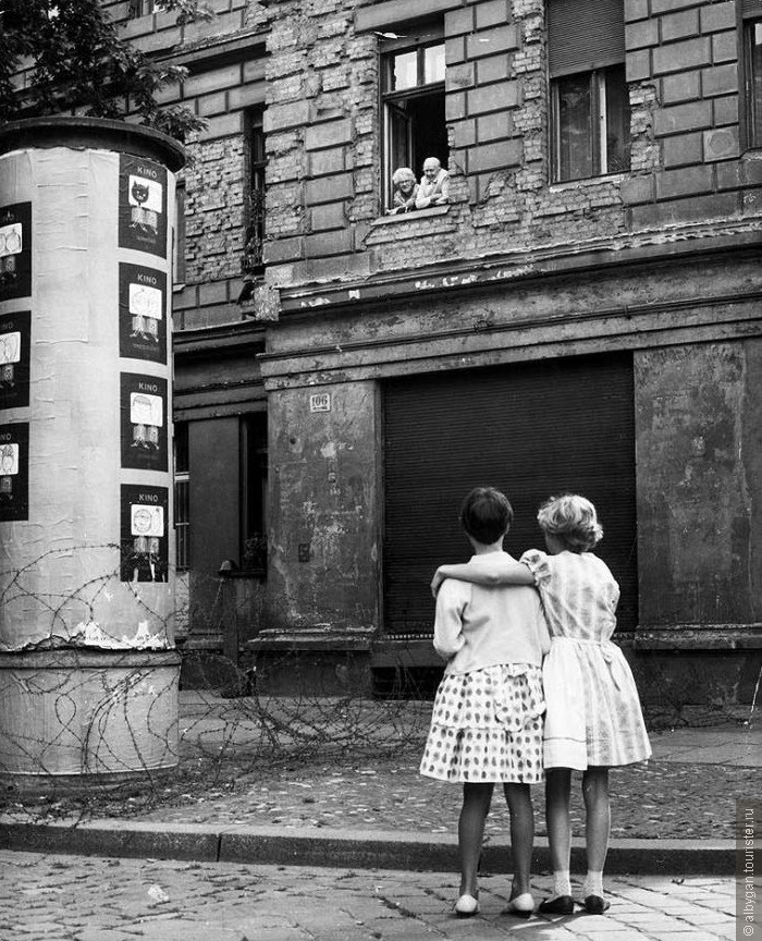 Фото из интернета. Две девочки на улице Западной Германии разговаривают со своими бабушкой и дедушкой в окне дома в восточной зоне, отделенной баррикадой из колючей проволоки, 14 августа 1961 года. (Keystone, Getty Images)