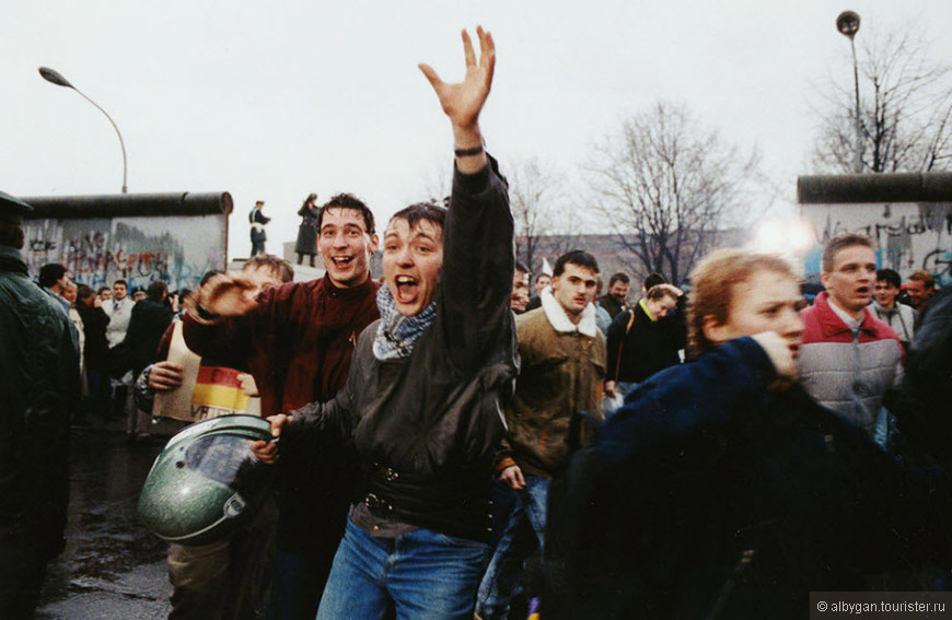 Молодые жители Восточного Берлина кричат от радости, пробегая через проход в Западный Берлин у Бранденбургских ворот 23 декабря 1989 года. Тогда новое правительство Восточной Германии пообещало полностью открыть ворота к Рождеству. (Hansjoerg Krauss, AP)