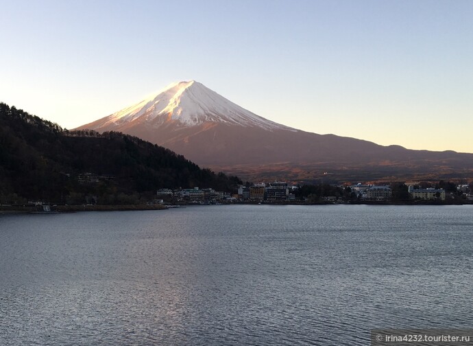 Вид на Фудзи сразу после восхода солнца. Цвет оранжевый - по цвету вулканических камушков на ее поверхности. Затем меняется положение солнца и цвет становится другим.. Озеро Кавагучико.