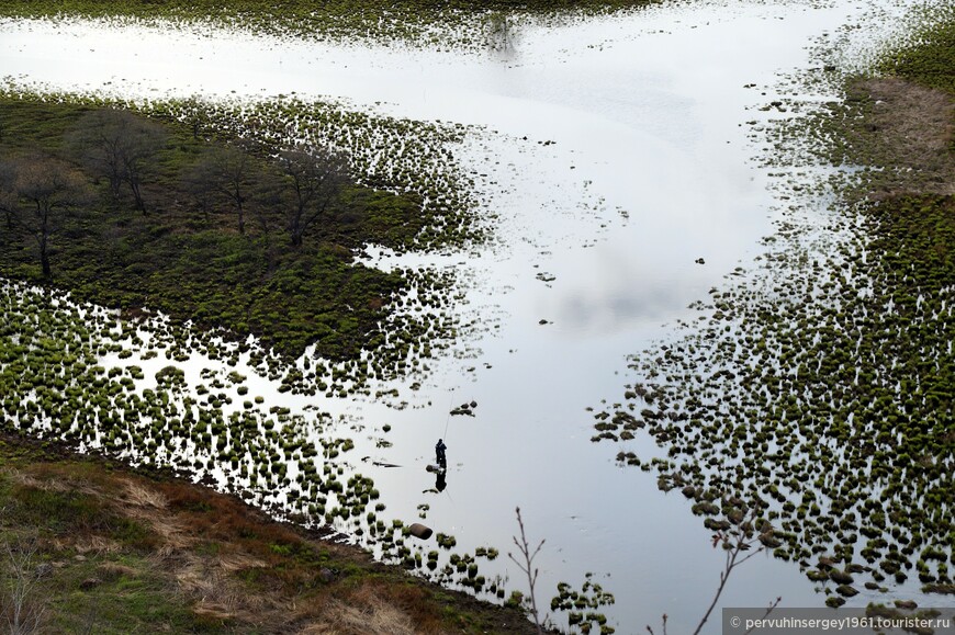 Затопленная пойма реки Биры с одиноким рыбаком