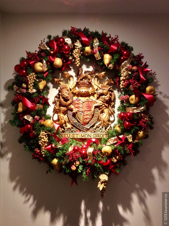 Герб Елизаветы II, обрамлённый венком, в сувенирном магазине Бакингемского дворца.
