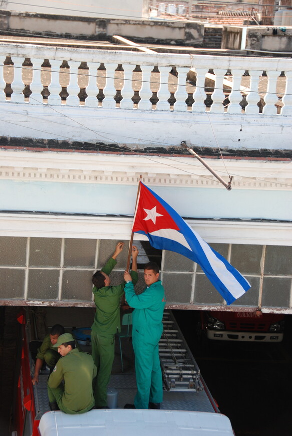 Пожарные ремонтируют флаг. Куба.