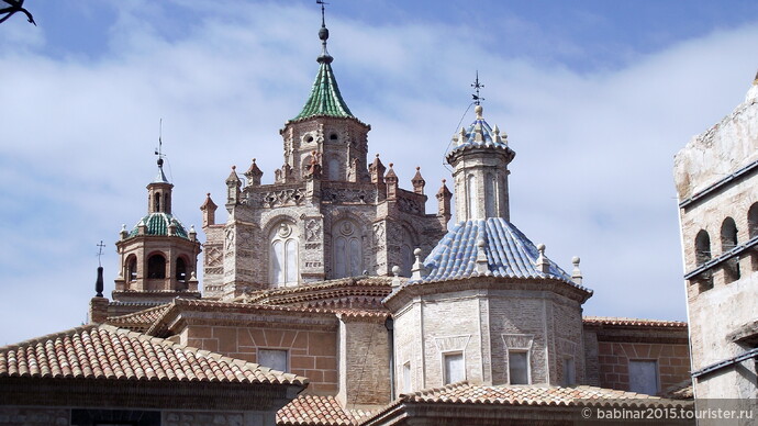Catedral de Santa Maria de Mediavilla. Окна нижнего яруса барабана купола обрамлены полукруглыми кирпичными дугами и украшены медальонами с портретами человеческих голов эпохи Возрождения.