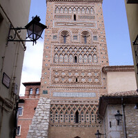 Torre de San Martín. Остроконечный свод прохода внизу башни схож с воротами остальных четырех башен мудехар города. С башней связана еще одна легенда о городе: в XIV веке два мастера по камню Омар и Абдалла, друзья по жизни, жившие в Теруэле, влюбились в одну девушку - прекрасную Зорайду. Они оба пришли к отцу девушки просить ее руки. Отец же решил так: пусть молодые люди построят по башне. Чья башня окажется лучше, тот и жениться на Зорайде.  Омар первым закончил свою работу, построив башню Сан Мартин. Но когда он показал ее народу, то люди увидели, что башня крива. Тогда мастер с горя бросился вниз со своей кривой башни. Через несколько недель работу закончил Абдалла. Он построил башню Сан Сальвадор. Народ признал эту башню более совершенным творением. Зорайда и Абдалла поженились. Конец. А до Сан-Сальвадора ещё дойдем.