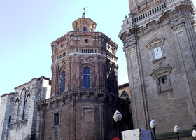 Кафедральный Собор Святой Марии (La Catedral de Santa María de Tudela). Над романским порталом северного трансепта нависают готические стрельчатые окна, рядом из кирпича выстроена часовня Святой Анны. Далее барочная колокольня XVIII века с часами