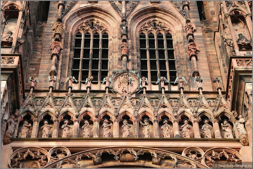 Галерея апостолов (внизу) и группа ангелов, играющих на трубах, (вверху), расположенные над центральной розеткой.