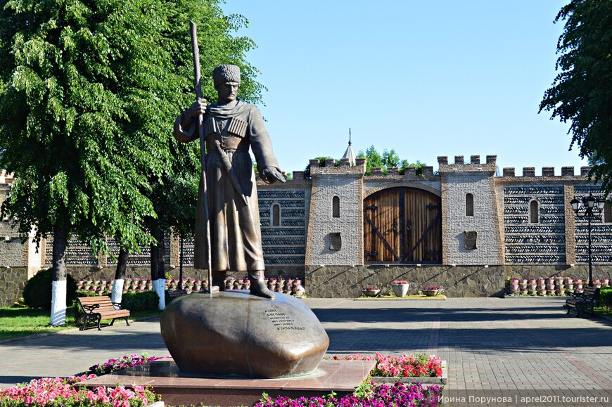 Памятник Дзаугу Бугулову – основателю поселения на фоне стилизованной крепости