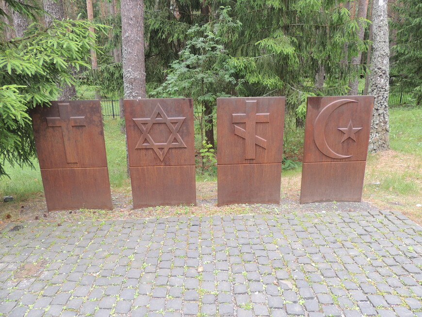 На металлических плитах изображены символы четырех религий - Католицизм, Иудаизм, Православие, Ислам (слева-направо). 
