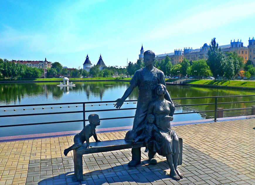 Памятник семье рядом с водоемом