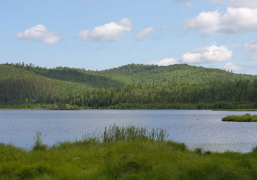 Озеро окружено холмами, поросшими тайгой