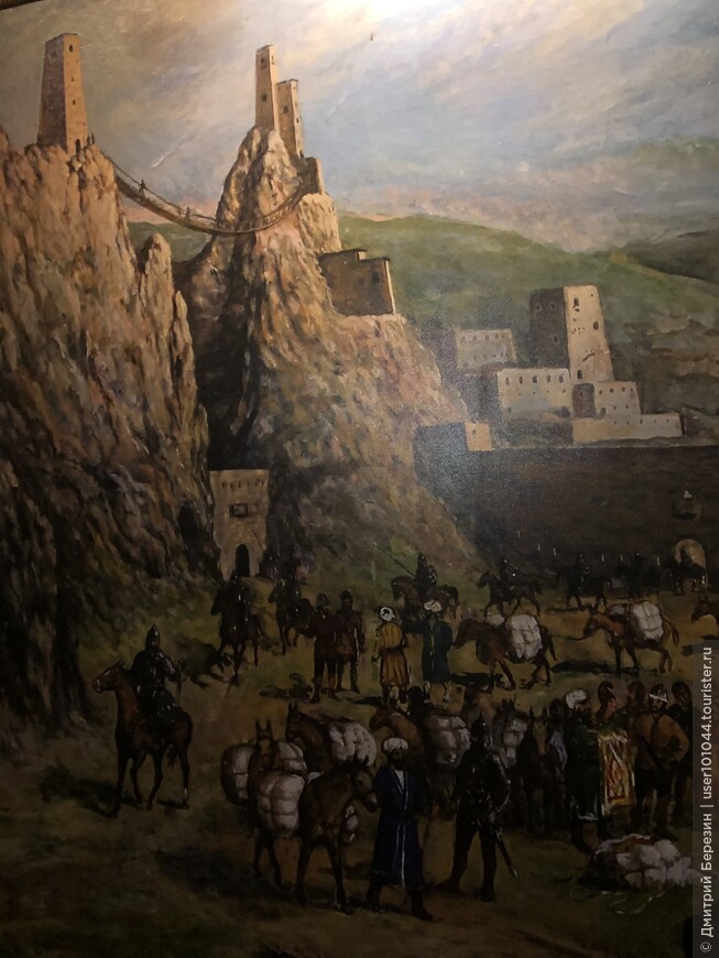 Картина в этнографическом музее Магаса (Вовнушки с подвесным мостом и торговцы каравана Шелкового пути)
