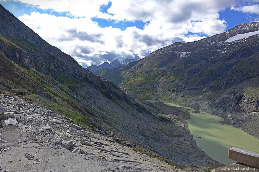 Ледниковое озеро и центр Франца Иосифа на склоне горы. В слайде при приближении видна наша тропа с точками туристов, настолько высоко мы стоим.