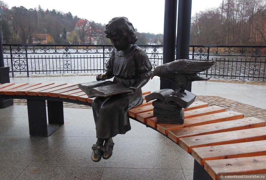 Скульптура Девочка с книгой. В книге выбиты строки, которые можно прочесть.