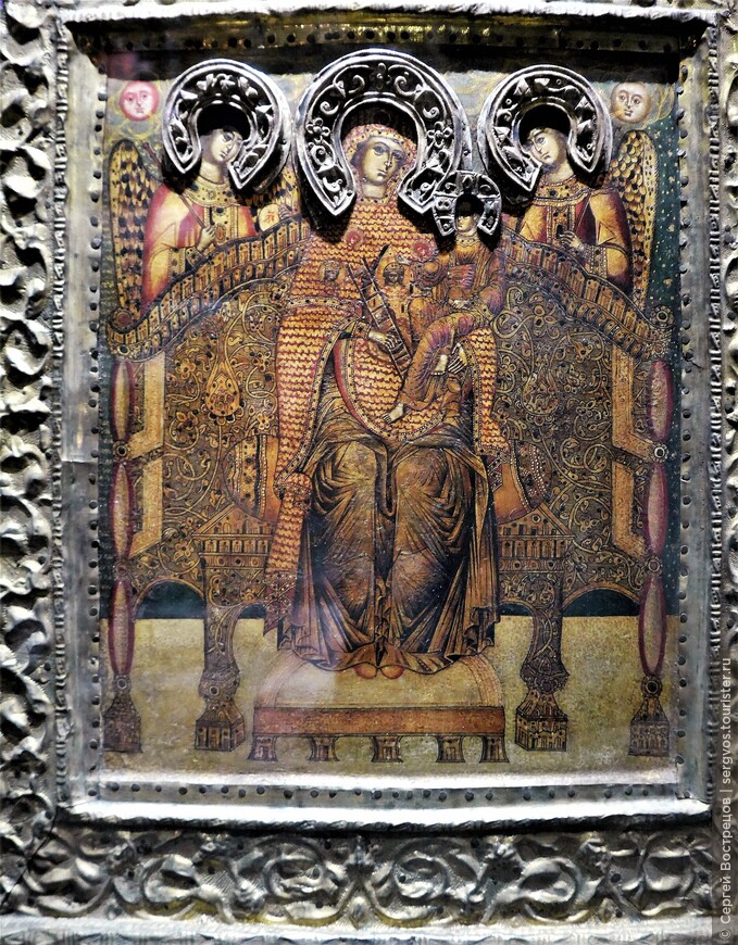 Согласно этикетке, название этой иконы «Богоматерь на троне с младенцем и двумя ангелами», датируется она серединой XVI – началом XVII века.  