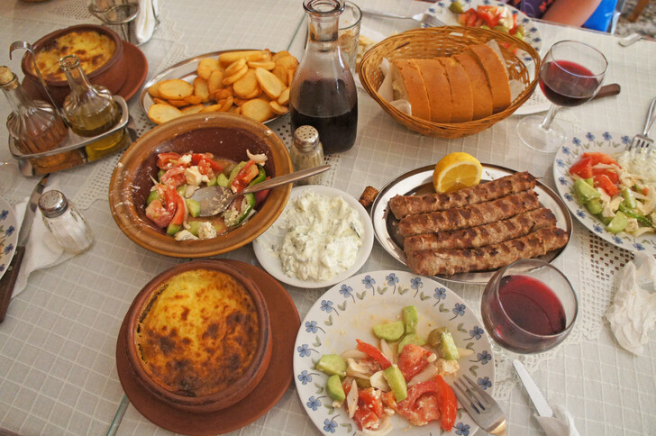 Традиционное греческое застолье, с мусакой, мясом и салатами