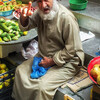 Торговец фруктов и овощей на рынке в морском порту Маската