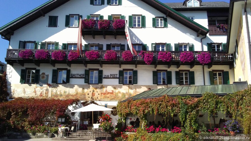 Традиционные австрийские дома с деревянными балконами, потопающими в цветах.