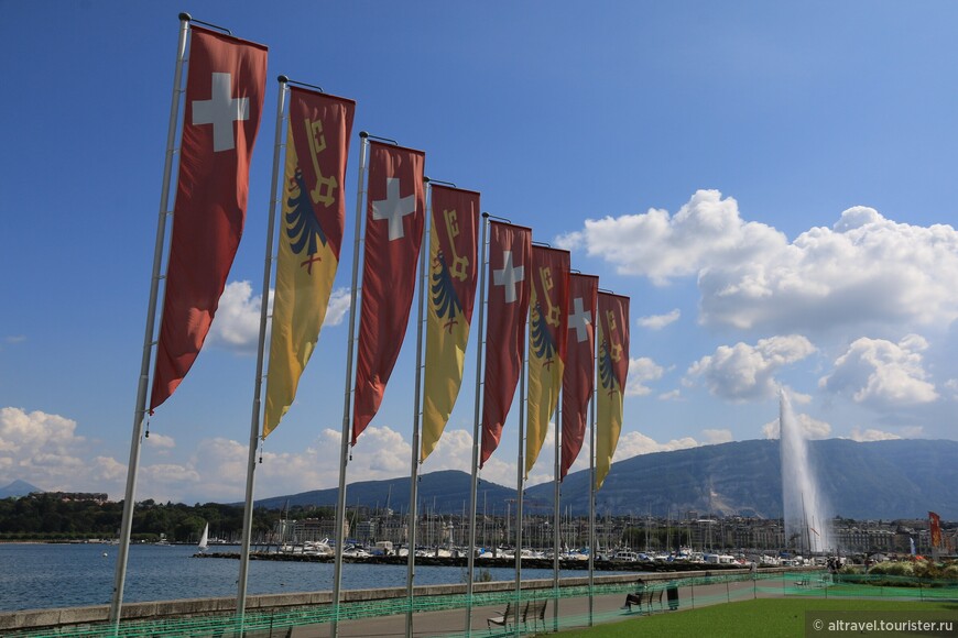 Флаги Швейцарии и Женевы на набережной Вильсона, чуть подальше - женевский фонтан