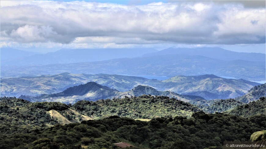 Вид со смотровой площадки на озеро Ареналь. На заднем плане - силуэты трех вулканов, входящих в Вулканическую дугу Центральной Америки.