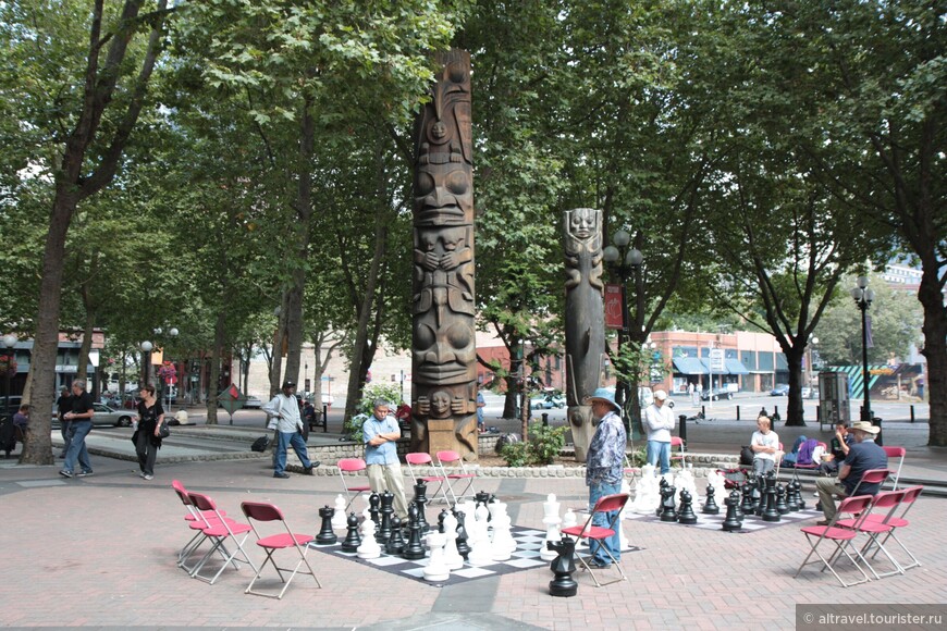 Индейские скульптуры и любители шахмат в Западном парке (Occidental Park). Снимок 2011 года.
