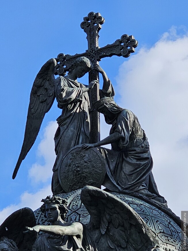 Коленопреклонённая Россия перед ангелом. Она опирается на щит с двуглавым орлом и датой «1862». Фигуры выполнены И.Н.Шредером.