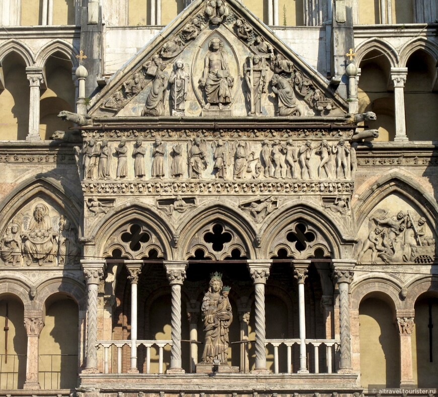 Центральным элементом фасада является портик, над которым в середине 13-го века была надстроена готическая лоджия со статуей Девы Марии с Младенцем. В тимпане выше статуи — барельефы с впечатляющими сценами Страшного суда. Фото из Википедии.