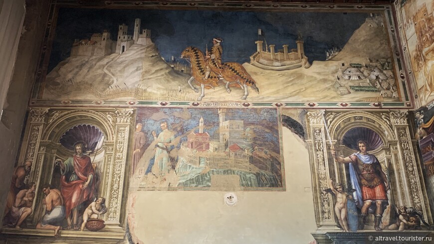 На стене напротив Маэсты видно сразу несколько фресок: наверху - длинная фреска Мартини со всадником, под ней - приписываемая Дуччо фреска с замком, по бокам - двое святых в исполнении Содомы (16-й век).