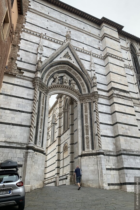 Изумительный дверной портал в левом нефе «нового» собора - прекрасный образец сиенской готики, хоть и ведёт из «ниоткуда» в «никуда».