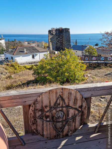 Общий вид на сохранившуюся территорию крепости и круглую башню Ашага-Куле на фоне Чёрного моря.