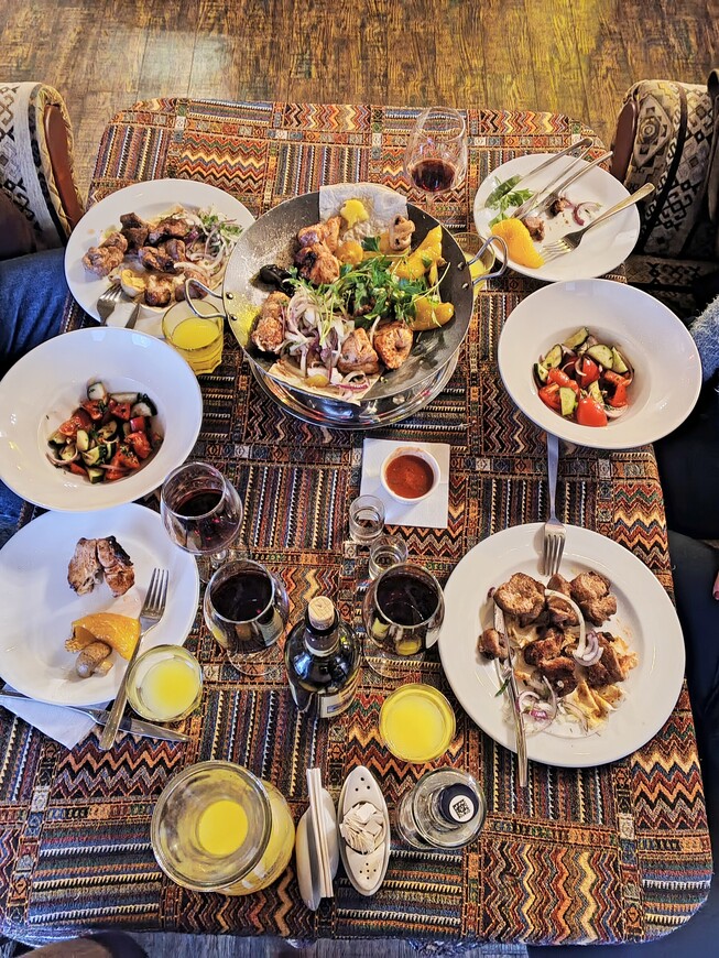 В центре стола стоит азербайджанское блюдо садж. Так называется и сковорода, в которой он готовится. Смысл приготовления заключается в обжаривании мяса и овощей с добавлением кавказских специй и зелени. Под сковородой на подставках установлена небольшая чаша с раскаленными углями. Так блюдо долго остаётся горячим. 