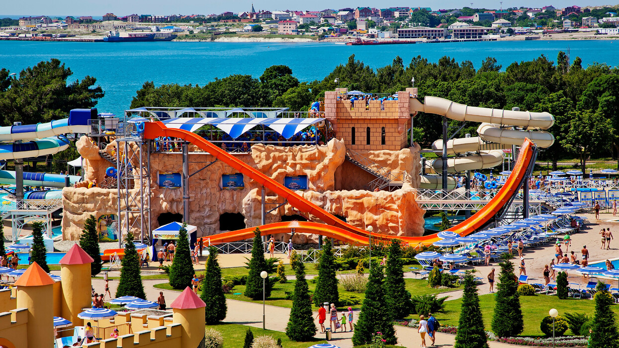 Яркий детский игровой комплекс с горками и фонтанчиками в аквапарке.