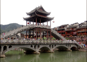 Одно из самых изящных сооружений Фэнхуана на реке – мост Хунцяо с закрытым коридором и возвышающейся беседкой, защищающими посетителей от дождя 