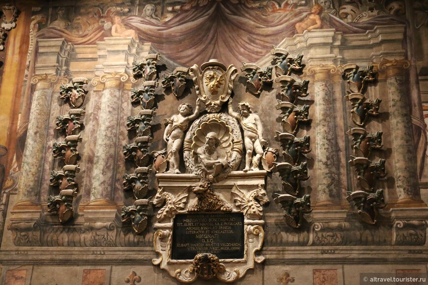 Полный символики мемориал болонского архиепископа Джироламо Бонкомпаньи (1672), окруженный со всех сторон маленькими зелёными драконами, гербом знатного итальянского рода Бонкомпаньи (главный же позолоченный дракон - на геральдическом щите). Расположенный ниже старик с книгой - Св. Иероним (итал. Джироламо) со своим прирученным львом (в окружении ещё двух драконов) уровнем ниже.