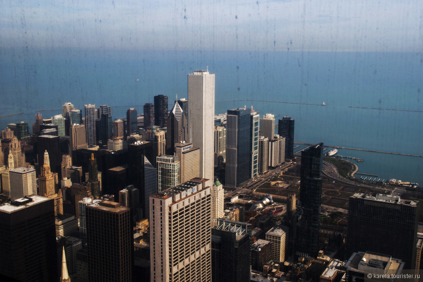 Высокое белое здание в центре - небоскреб Аон Центр, третий по величине в Чикаго. После завершения строительства в 1972 г. был самым высоким в мире зданием, облицованным мрамором, пока мрамор не обвалился. Сейчас здание заново облицовано гранитом. 