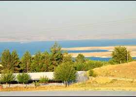 А это озеро с ярко-голубой водой и резко изрезанной береговой линией - не что иное как водохранилище Ататюрка, образовавшееся в результате затопления окрестных земель водами реки Евфрат после строительства огромной плотины. Проект GAP - Guneydogu Anadolu Projesi - предполагает устройство плотин на двух стратегически значимых реках региона - Тигре и Евфрате, с целью улучшения орошения окружающих земель и за счет этого улучшения экономической ситуации в этом исторически депрессивном регионе Турции. Но как и все в этом регионе, все не так просто - Сирия и Ирак обвиняют Турцию в умышленном регулировании уровня воды в реке.