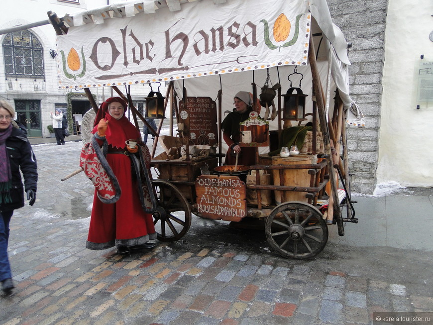 Продавщица сладостей в средневековых одеждах на Ратушной площади Таллина