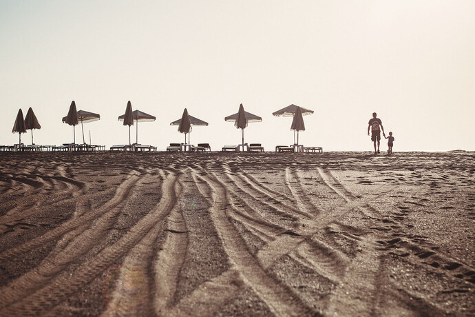 на походе к пляжу на песке следы от квадроцикла.
на нем разъезжает девушка, собирающая плату за зонтики