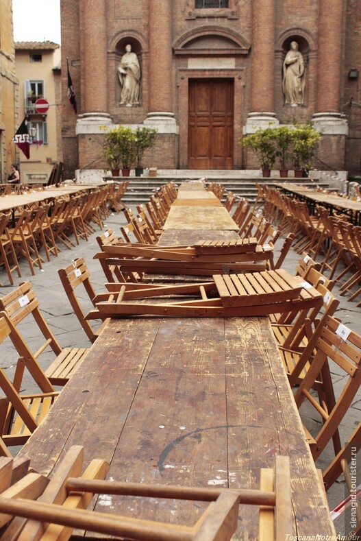 Фасад Церкви Святого Кристофора в Сиене. А на первом плане столы Квртала Сова, подготовка к прздничным ужинам перед Палио.